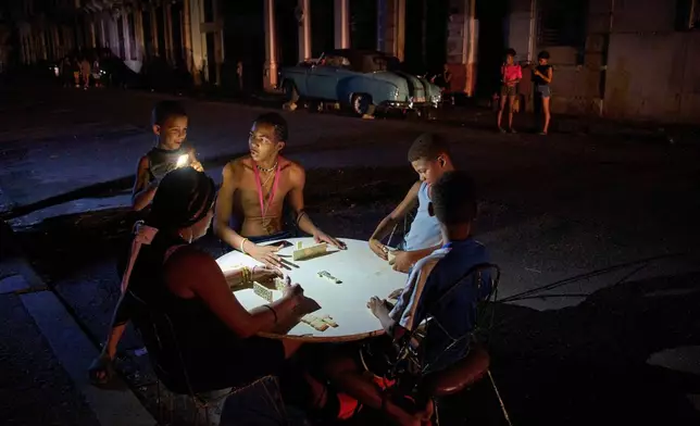 People play dominoes on the street during a blackout in Havana, Sept. 10, 2025. (AP Photo/Ramon Espinosa, File)