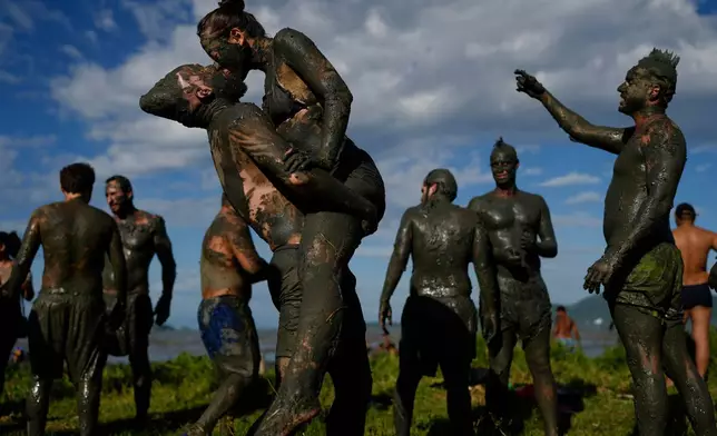 Revelers share a kiss during the traditional Mud Block carnival party in Paraty, Brazil, March 1, 2025. (AP Photo/Andre Penner, File)
