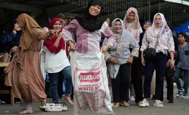 Muslim women react during a sack race as they celebrate Eid al-Fitr at a park in Quezon City, Philippines, March 31, 2025. (AP Photo/Aaron Favila, File)