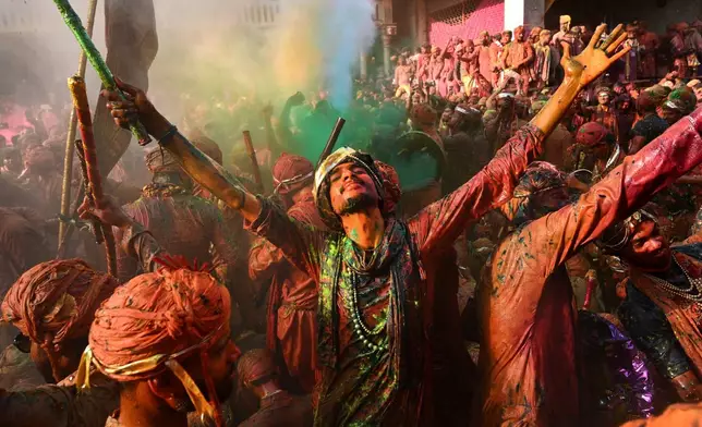 Villagers from Barsana and Nandgaon smeared with colors sing and dance as they participate in Lathmar Holi at Nandagram temple in Nandgaon village, 115 kilometers (70 miles) south of New Delhi, India, March 9, 2025. (AP Photo, File)