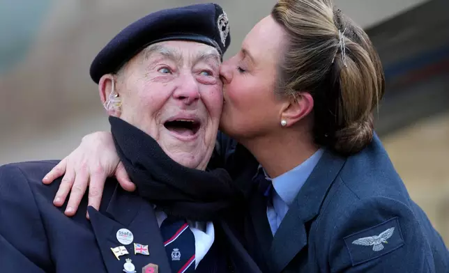 Henry Rice, a 98 year-old Normandy veteran, gets a kiss from Katie Ashby, founder and lead vocalist of D-Day Darlings, as SSAFA, the nation's oldest armed forces charity, kicks off the 80-day countdown to VE Day 80 at The Royal Albert Hall in London, Feb. 17, 2025. (AP Photo/Kirsty Wigglesworth, File)