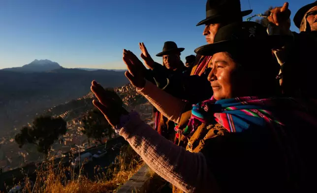 Aymara Indigenous people hold up their hands to receive the first rays of sunlight in celebration of the Andean New Year 5533, marking the Southern Hemisphere's winter solstice, in El Alto, Bolivia, June 21, 2025. (AP Photo/Juan Karita, File)