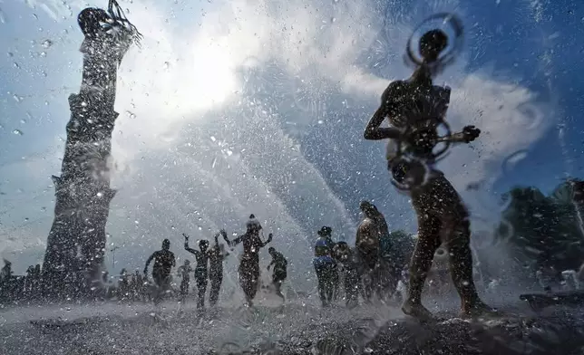 Children run through a water fountain in St. Petersburg, Russia, July 12, 2025. (AP Photo/Dmitri Lovetsky, File)
