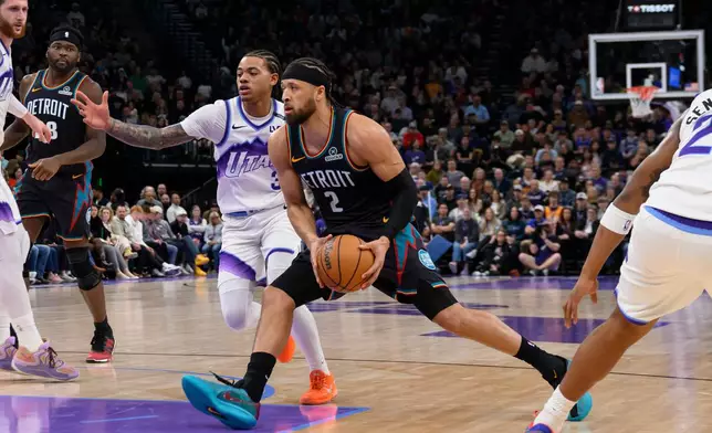 Detroit Pistons guard Cade Cunningham (2) drives to the basket past the defense of Utah Jazz guard Keyonte George, center rear, during the first half of an NBA basketball game, Friday, Dec. 26, 2025, in Salt Lake City. (AP Photo/Tyler Tate)