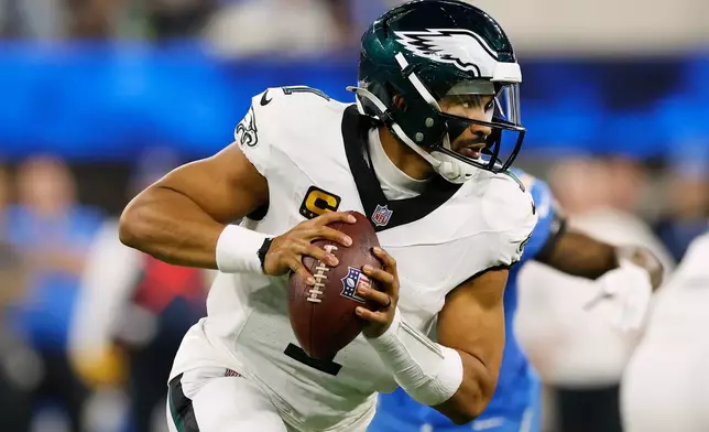 Philadelphia Eagles quarterback Jalen Hurts (1) rolls out during the second half of an NFL football game against the Los Angeles Chargers, Monday, Dec. 8, 2025, in Inglewood, Calif. (AP Photo/Caroline Brehman)