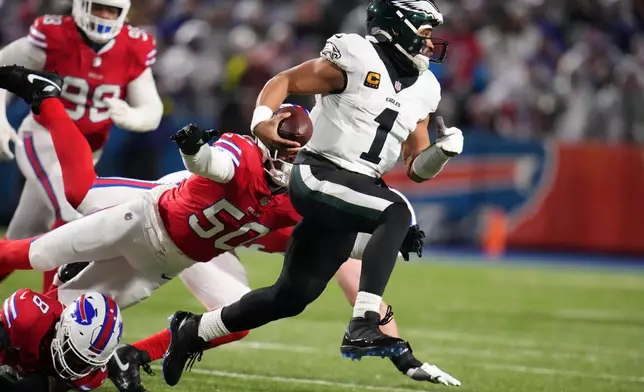 Philadelphia Eagles' Jalen Hurts, right, scrambles past Buffalo Bills' Greg Rousseau during the first half of an NFL football game, Sunday, Dec. 28, 2025, in Buffalo, N.Y. (AP Photo/Gene J. Puskar)
