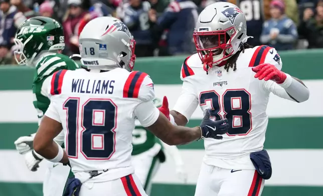 New England Patriots running back Rhamondre Stevenson (38) celebrates a touchdown against the New York Jets with teammate Kyle Williams (18) during the first half of an NFL football game, Sunday, Dec. 28, 2025, in East Rutherford, N.J. (AP Photo/Frank Franklin)