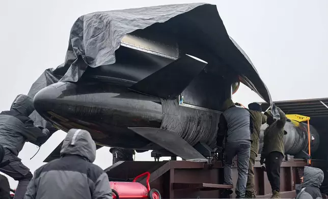 Workers and military inspect Ukrainian Fire Point's Flamingo missiles during handover to the military in an undisclosed location in Ukraine Thursday, Dec. 4, 2025. (AP Photo/Efrem Lukatsky)