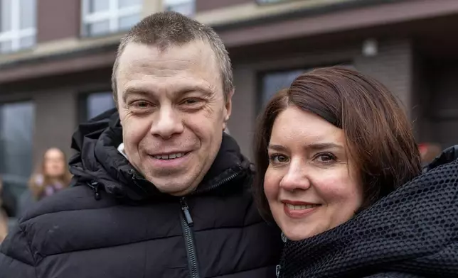 Uladzimir Labkovich, one of the released Belarusian prisoners and his wife Nina Labkovich smile as he arrives in Vilnius, Lithuania, Thursday, Dec. 18, 2025. (AP Photo/Mindaugas Kulbis)
