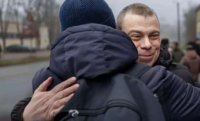 Uladzimir Labkovich, one of the released Belarusian prisoners embraces a relative as he arrives in Vilnius, Lithuania, Thursday, Dec. 18, 2025. (AP Photo/Mindaugas Kulbis)