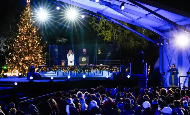 An American Sign Language interpreter, right, signs as President Donald Trump, accompanied by first lady Melania Trump, speaks following the lighting of the National Christmas Tree on the Ellipse, Thursday, Dec. 4, 2025, near the White House in Washington. (AP Photo/Julia Demaree Nikhinson)