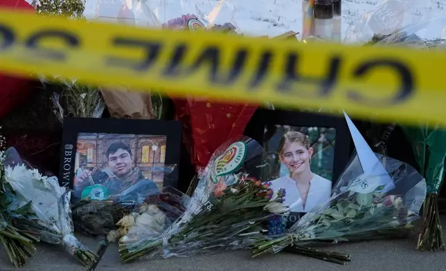 Photos of Brown University shooting victims Mukhammad Aziz Umurzokov, left, and Ella Cook, are seen amongst flowers at a makeshift memorial outside the Engineering Research Center, Tuesday, Dec. 16, 2025, in Providence, R.I.(AP Photo/Robert F. Bukaty)