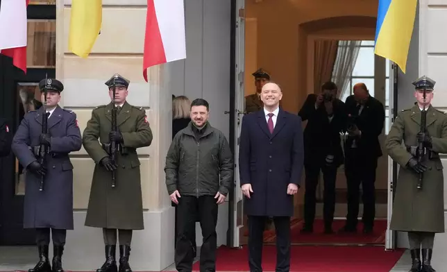 Polish President Karol Nawrocki, center, and Ukrainian President Volodymyr Zelenskyy attend an official welcome ceremony before their meeting at the Presidential Palace in Warsaw, Poland, Friday, Dec. 19, 2025. (AP Photo/Czarek Sokolowski)