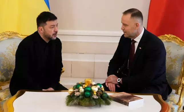 Polish President Karol Nawrocki, right and Ukrainian President Volodymyr Zelenskyy speak, during their meeting at the Presidential Palace in Warsaw, Poland, Friday, Dec. 19, 2025. (AP Photo/Czarek Sokolowski)
