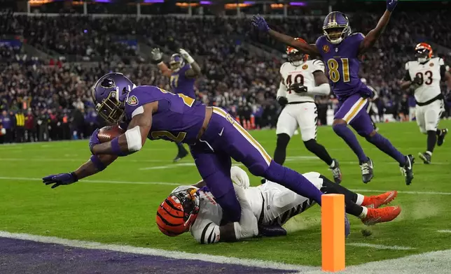 Baltimore Ravens running back Derrick Henry (22) scores a touchdown past Cincinnati Bengals linebacker Demetrius Knight Jr. (44) as Baltimore Ravens wide receiver Devontez Walker (81) celebrates during the first half of an NFL football game, Thursday, Nov. 27, 2025, in Baltimore. (AP Photo/Stephanie Scarbrough)