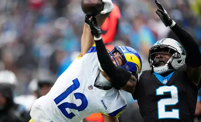 Los Angeles Rams wide receiver Puka Nacua catches a pass over Carolina Panthers cornerback Mike Jackson during the second half of an NFL football game, Sunday, Nov. 30, 2025, in Charlotte, N.C. (AP Photo/Jacob Kupferman)