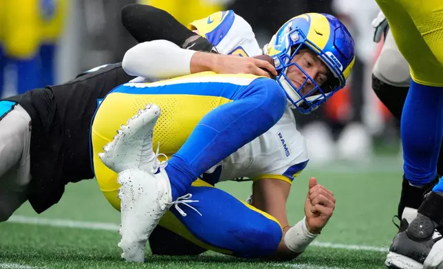 Los Angeles Rams quarterback Matthew Stafford is sacked by Carolina Panthers safety Lathan Ransom during the second half of an NFL football game, Sunday, Nov. 30, 2025, in Charlotte, N.C. (AP Photo/Jacob Kupferman)