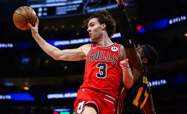Chicago Bulls guard Josh Giddey passes while Atlanta Hawks forward Onyeka Okongwu, right, defends during the first half of an NBA basketball game, Sunday, Dec. 21, 2025, in Atlanta. (AP Photo/Colin Hubbard)