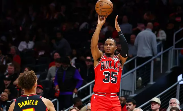 Chicago Bulls forward Isaac Okoro (35) looks to shoot over Atlanta Hawks guard Dyson Daniels, left, during the first half of an NBA basketball game, Sunday, Dec. 21, 2025, in Atlanta. (AP Photo/Colin Hubbard)