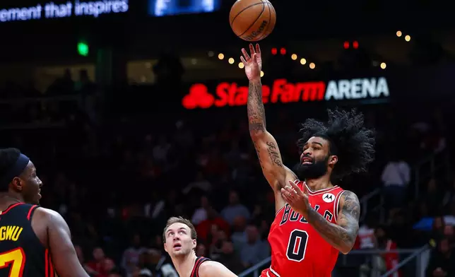 Chicago Bulls guard Coby White (0) shoots over Atlanta Hawks forward Onyeka Okongwu, left, during the first half of an NBA basketball game, Sunday, Dec. 21, 2025, in Atlanta. (AP Photo/Colin Hubbard)