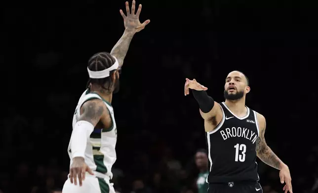 Brooklyn Nets guard Tyrese Martin (13) celebrates a three-point basket during the first half of an NBA basketball game against the Milwaukee Bucks, Sunday, Dec. 14, 2025, in New York. (AP Photo/Heather Khalifa)