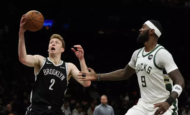 Brooklyn Nets forward Danny Wolf (2) drives to the basket past Milwaukee Bucks forward Bobby Portis (9) during the first half of an NBA basketball game, Sunday, Dec. 14, 2025, in New York. (AP Photo/Heather Khalifa)