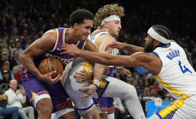 Phoenix Suns forward Oso Ighodaro, left, grabs a rebound against Golden State Warriors guard Brandin Podziemski, center, and Warriors guard Moses Moody (4) during the first half of an NBA basketball game Thursday, Dec. 18, 2025, in Phoenix. (AP Photo/Ross D. Franklin)
