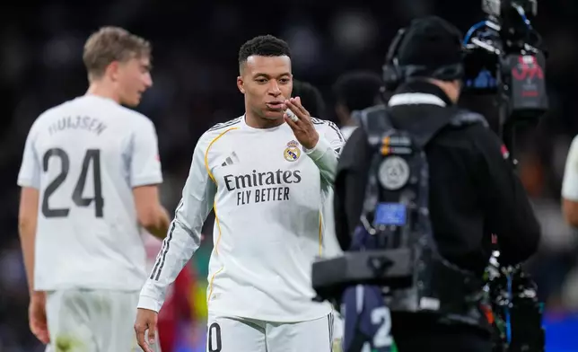Real Madrid's Kylian Mbappe blows a kiss towards the TV camera as he celebrates after scoring his sides second goal during the Spanish La Liga soccer match between Real Madrid and Sevilla in Madrid, Spain, Saturday, Dec. 20, 2025. (AP Photo/Manu Fernandez)