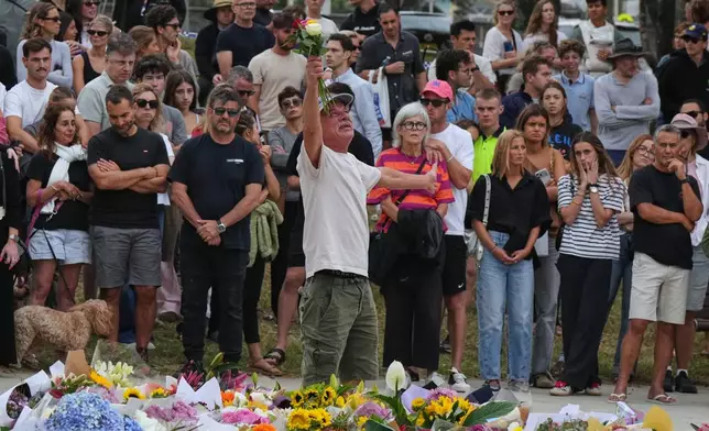 A man gestures as he lays flowers at a tribute for shooting victims outside the Bondi Pavilion at Sydney's Bondi Beach, Monday, Dec. 15, 2025, a day after a shooting. (AP Photo/Mark Baker)