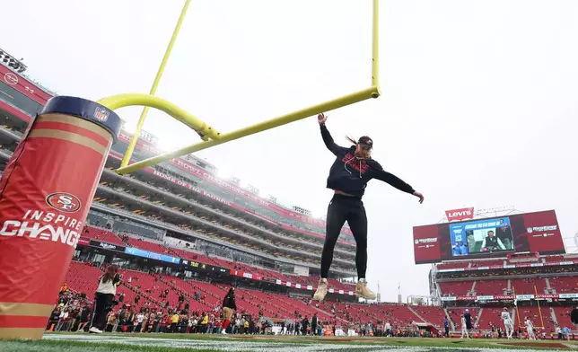 San Francisco 49ers tight end George Kittle jumps to touch the goalpost before an NFL football game against the Tennessee Titans, Sunday, Dec. 14, 2025, in Santa Clara, Calif. (AP Photo/Jed Jacobsohn)