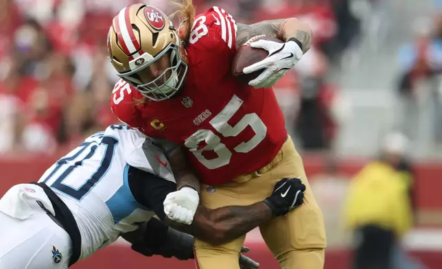 San Francisco 49ers tight end George Kittle (85) breaks a tackle by Tennessee Titans safety Kendell Brooks, left, during the first half of an NFL football game, Sunday, Dec. 14, 2025, in Santa Clara, Calif. (AP Photo/Jed Jacobsohn)