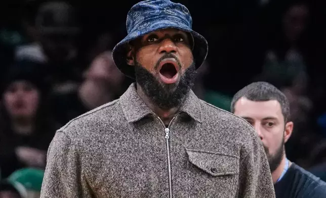 Los Angeles Lakers' Lebron James yawns while standing next to the bench during an NBA basketball game against the Boston Celtics, Friday, Dec. 5, 2025, in Boston. (AP Photo/Charles Krupa)