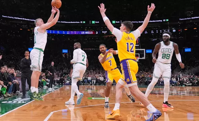 Boston Celtics guard Payton Pritchard, left, takes a 3-point shot against the Los Angeles Lakers during the first half of an NBA basketball game, Friday, Dec. 5, 2025, in Boston. (AP Photo/Charles Krupa)