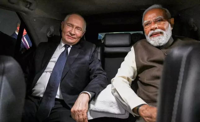 Russian President Vladimir Putin, and Indian Prime Minister Narendra Modi sit inside a limousine after arriving at the Palam Air Base in New Delhi, India, on Thursday, Dec. 4, 2025. (Grigory Sysoyev, Sputnik, Kremlin Pool Photo via AP)