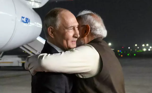 Russian President Vladimir Putin, left, and Indian Prime Minister Narendra Modi embrace each other at the Palam Air Base in New Delhi, India, Thursday, Dec. 4, 2025. (Grigory Sysoyev, Sputnik, Kremlin Pool Photo via AP)
