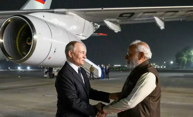 Russian President Vladimir Putin, left, and Indian Prime Minister Narendra Modi greet each other at the Palam Air Base in New Delhi, India, on Thursday, Dec. 4, 2025. (Grigory Sysoyev, Sputnik, Kremlin Pool Photo via AP)