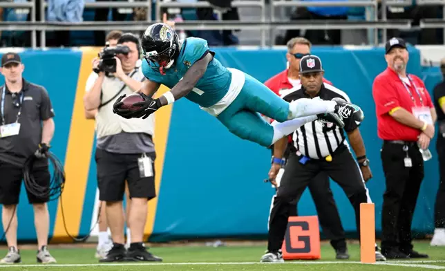 Jacksonville Jaguars running back Travis Etienne Jr. (1) scores a touchdown against the New York Jets during the second half of an NFL football game, Sunday, Dec. 14, 2025, in Jacksonville, Fla. (AP Photo/Phelan M. Ebenhack)