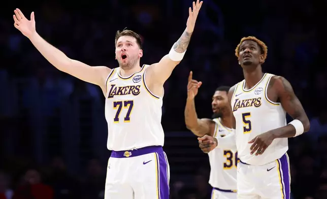 Los Angeles Lakers guard Luka Doncic (77) reacts to a call as center Deandre Ayton (5) looks on and guard Marcus Smart, back center, gestures during the first half of an NBA basketball game against the Sacramento Kings, Sunday, Dec. 28, 2025, in Los Angeles. (AP Photo/Jessie Alcheh)