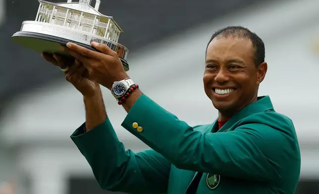 FILE - Tiger Woods wears his green jacket holding the winning trophy after the final round for the Masters golf tournament, Sunday, April 14, 2019, in Augusta, Ga. (AP Photo/Matt Slocum, File)
