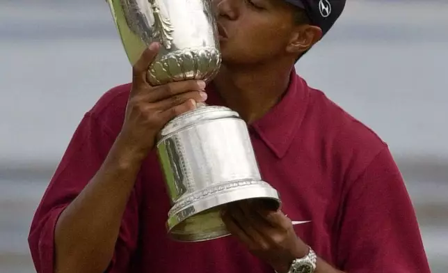 FILE - Tiger Woods kisses the winner's trophy after capturing the 100th U.S. Open Golf Championship at the Pebble Beach Golf Links, in Pebble Beach, Calif., Sunday, June 18, 2000. (AP Photo/Elise Amendola, File)