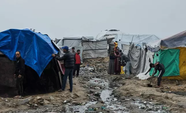 Displaced Palestinians repair their tents at a tent camp on the beach after a stormy weather in Gaza City, Wednesday, Dec. 10, 2025. (AP Photo/Jehad Alshrafi)