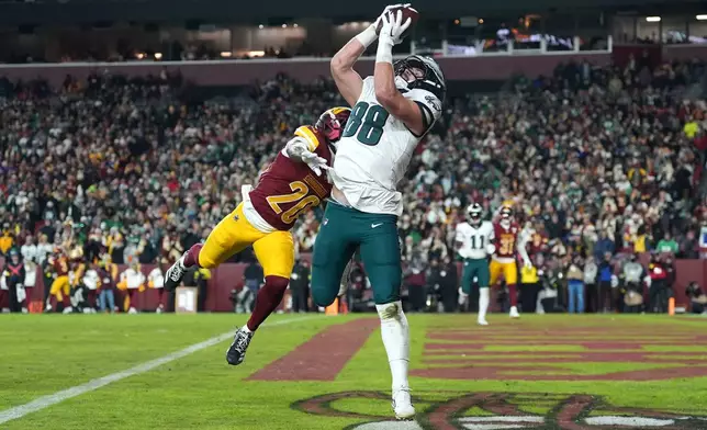 Philadelphia Eagles tight end Dallas Goedert (88) catches a pass for a touchdown against Washington Commanders safety Quan Martin (20) during the second half of an NFL football game, Saturday, Dec. 20, 2025, in Landover, Md. (AP Photo/Stephanie Scarbrough)