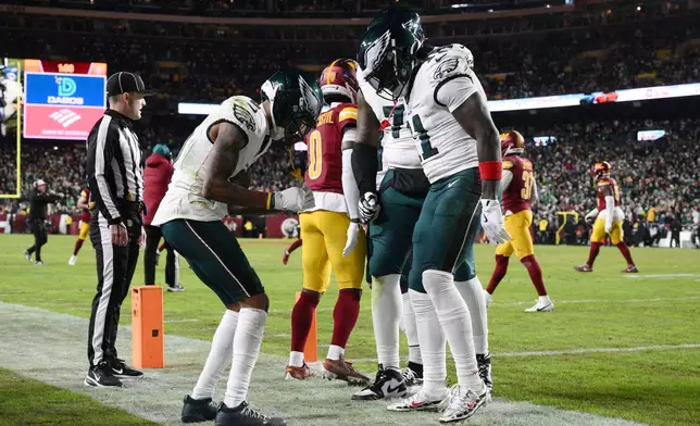 Philadelphia Eagles wide receiver Devonta Smith, front left, celebrates with teammates after his touchdown against the Washington Commanders during the first half of an NFL football game, Thursday, Dec. 20, 2025, in Landover, Md. (AP Photo/Nick Wass)