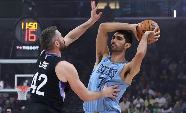 Memphis Grizzlies forward Santi Aldama (7) looks for the play as Utah Jazz forward Kevin Love (42) defends during the first half of an NBA basketball game, Tuesday, Dec. 23, 2025, in Salt Lake City. (AP Photo/Rob Gray)