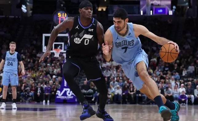 Memphis Grizzlies forward Santi Aldama (7) drives to the basket against Utah Jazz forward Taylor Hendricks (0) during the first half of an NBA basketball game, Tuesday, Dec. 23, 2025, in Salt Lake City. (AP Photo/Rob Gray)