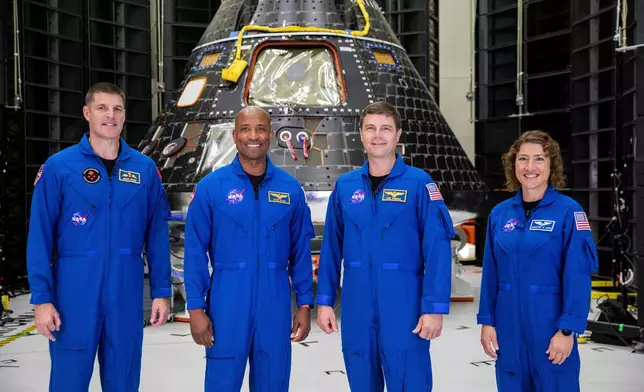 FILE - In this photo provided by NASA, Artemis II crew members, from left, Jeremy Hansen, Victor Glover, Reid Wiseman and Christina Koch, stand together at NASA's Kennedy Space Center in Florida, in front of an Orion crew module on Tuesday, Aug. 8, 2023. (Kim Shiflett/NASA via AP, File)
