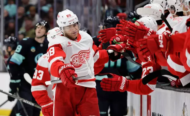 Detroit Red Wings right wing Patrick Kane (88) is congratulated after scoring against the Seattle Kraken during the third period of an NHL hockey game Saturday, Dec. 6, 2025, in Seattle. (AP Photo/John Froschauer)