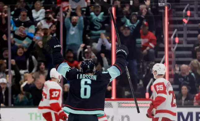 Seattle Kraken defenseman Adam Larsson (6) reacts to a goal by center Chandler Stephenson (9) against the Detroit Red Wings during the second period of an NHL hockey game Saturday, Dec. 6, 2025, in Seattle. (AP Photo/John Froschauer)
