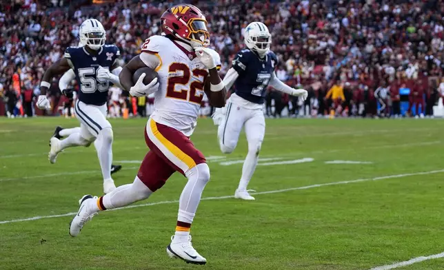 Washington Commanders running back Jacory Croskey-Merritt (22) scores on a touchdown run during the second half an NFL football game against the Dallas Cowboys Thursday, Dec. 25, 2025, in Landover, Md. (AP Photo/Stephanie Scarbrough)