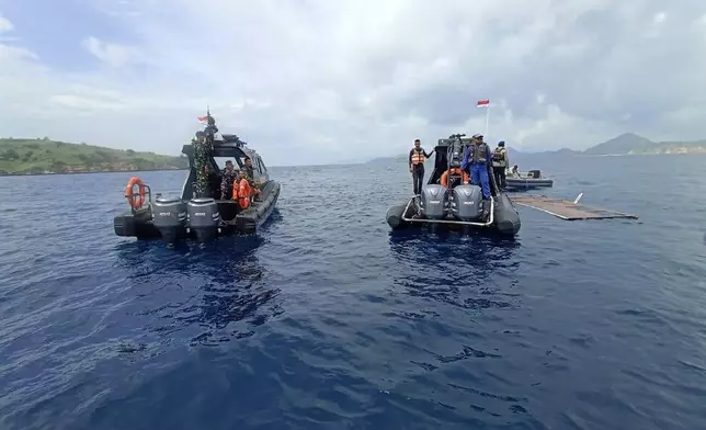 In this photo released by the Indonesian National Search and Rescue Agency (BASARNAS) on Saturday, Dec. 27, 2025, rescuers examine the waters where a debris believed to be from a tour boat that sank was found, near Padar Island within Komodo National Park, Indonesia. (BASARNAS via AP)